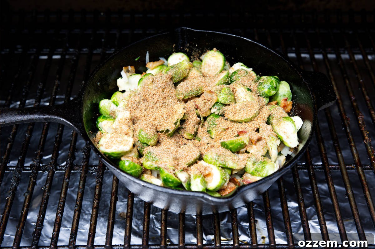 Brussels sprouts in a skillet with Cajun seasoning sprinkled on top, ready to be tossed