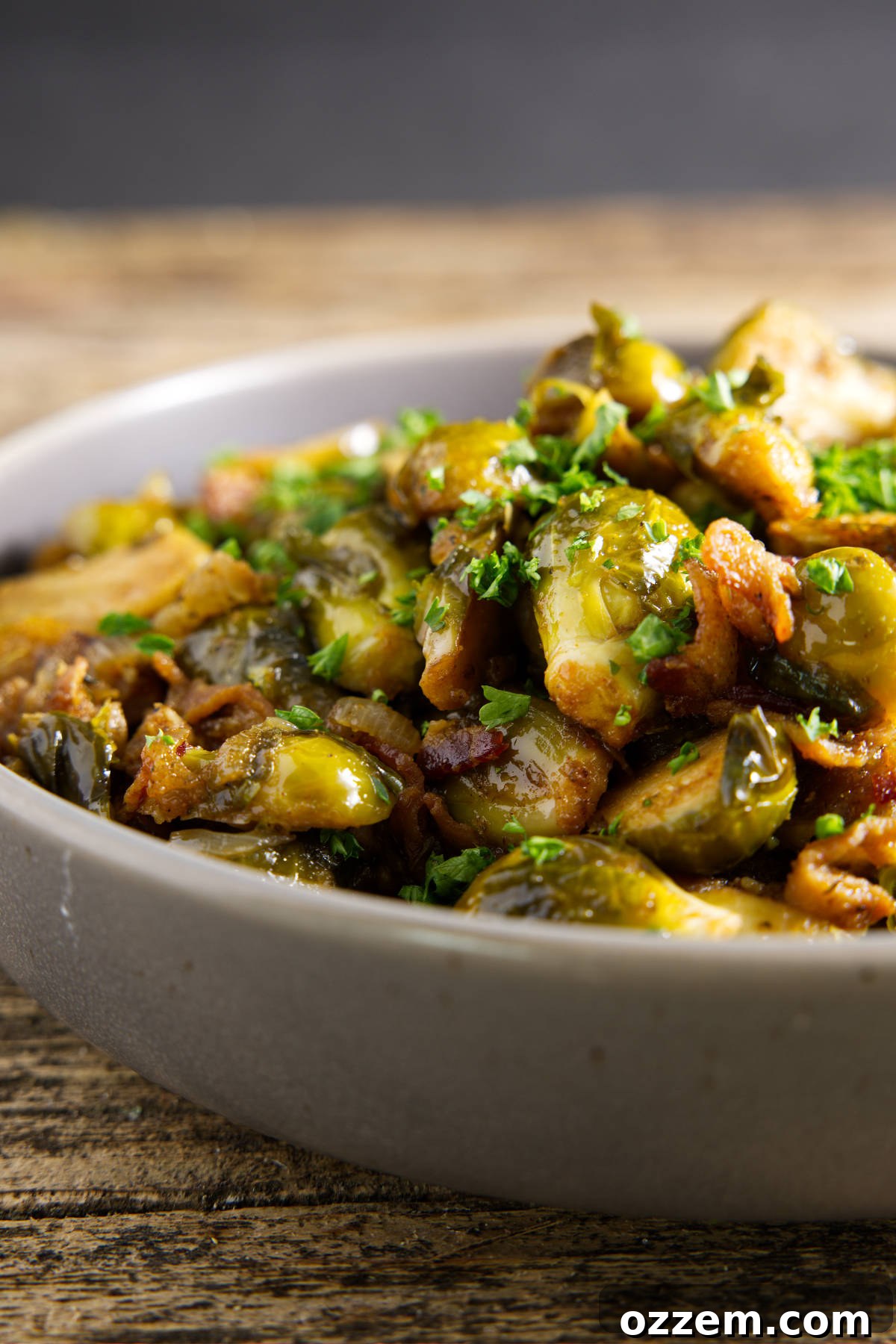 A bowl of smoked Brussels sprouts served on a table, beautifully drizzled with hot honey