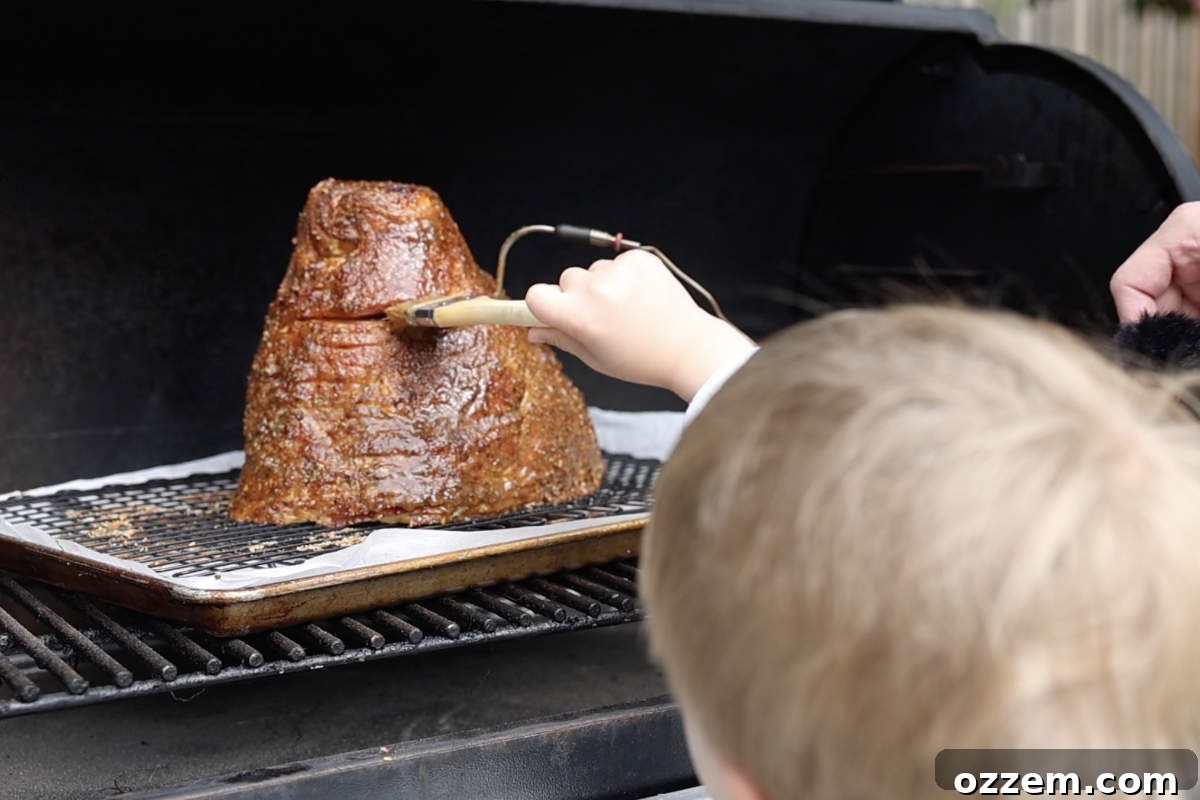 Brushing the rich pineapple bourbon glaze onto the spiral ham as it continues to smoke on the Traeger, creating a sticky, caramelized finish.