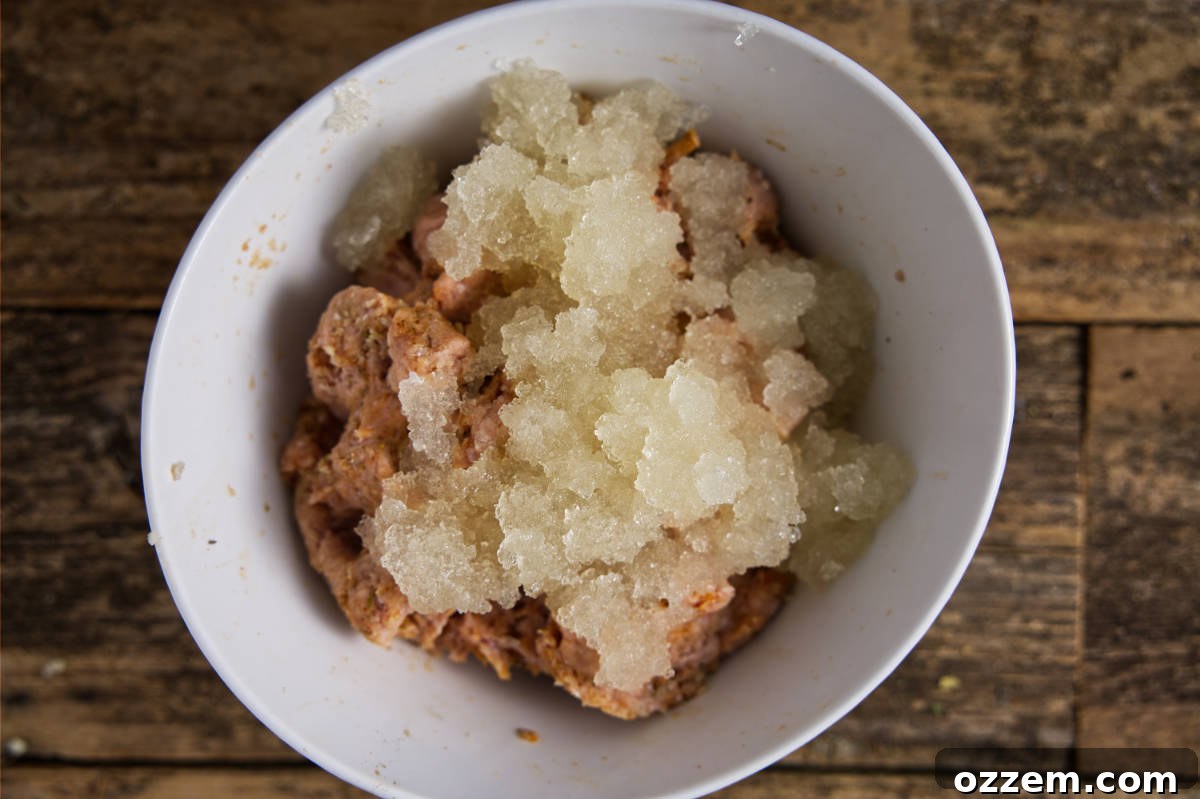 Mixing the small granules of chicken stock gelatin into the bowl of turkey burger ingredients.