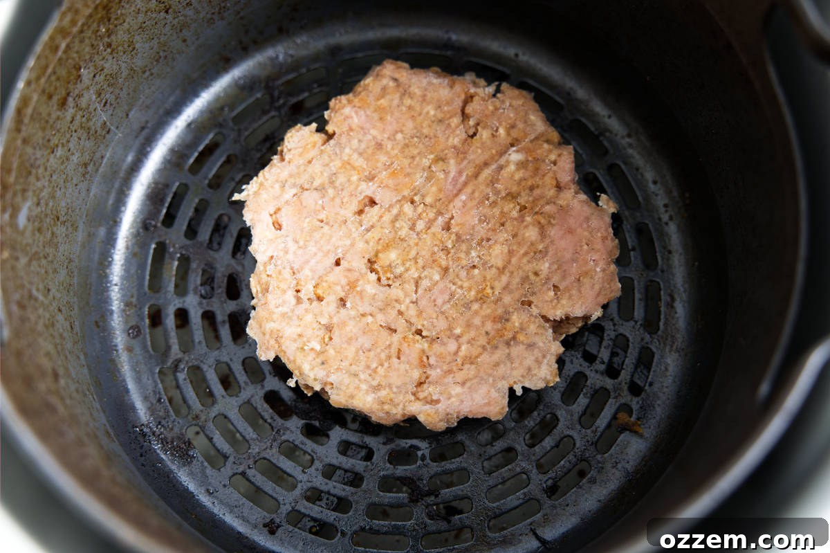 Cooking the air fryer turkey burgers in the air fryer basket until golden brown.