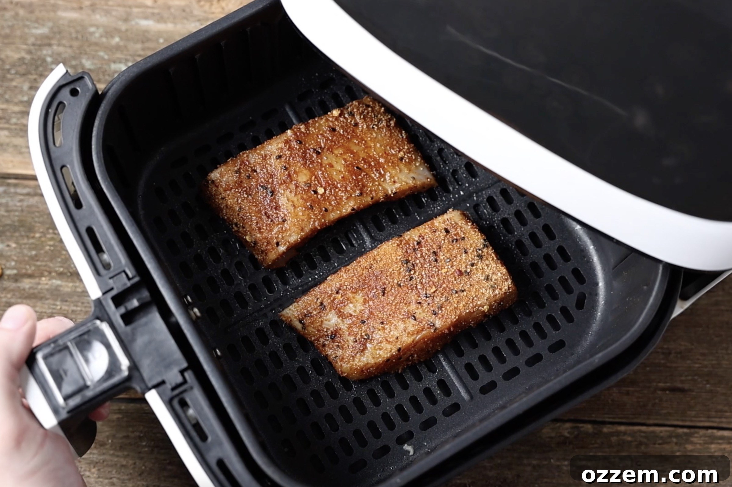two seasoned halibut fillets in the air fryer basket