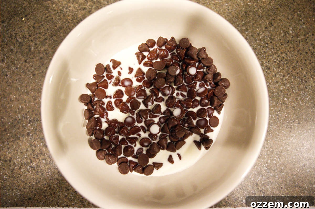 Chocolate chips and cream in a bowl for ganache.
