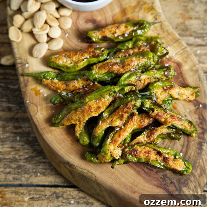 Air fryer shishito peppers on cutting board with cherry preserves and almonds
