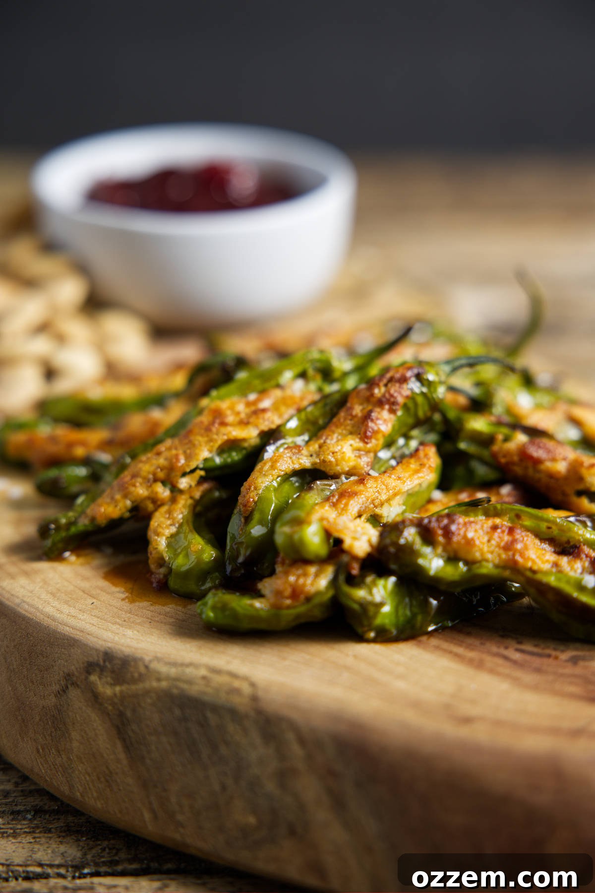 Air fryer shishito peppers in a pile on a cutting board