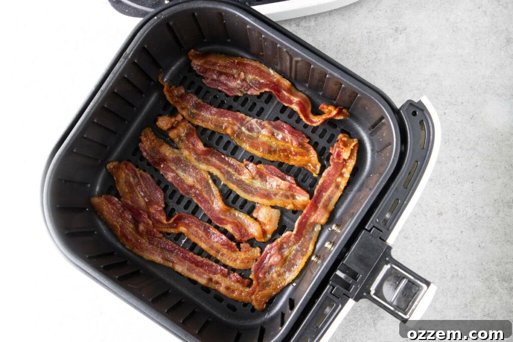 Crispy Air Fryer Frozen Asparagus 6 Cooked bacon in an air fryer basket.