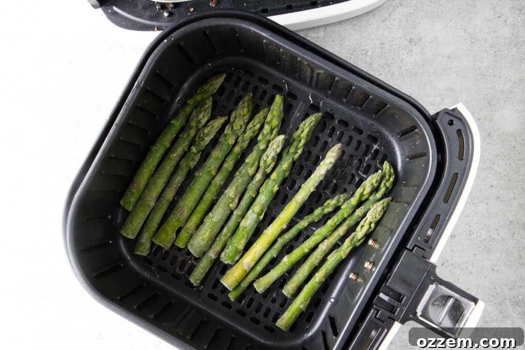 Crispy Air Fryer Frozen Asparagus 7 Frozen asparagus in air fryer basket.