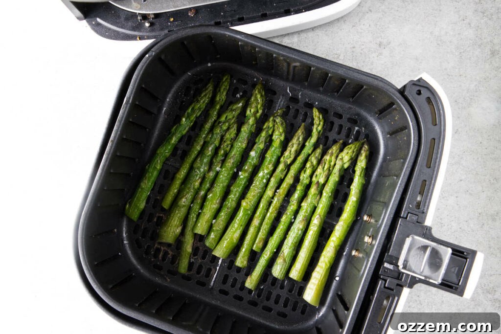 Crispy Air Fryer Frozen Asparagus 8 Cooked asparagus in air fryer basket.