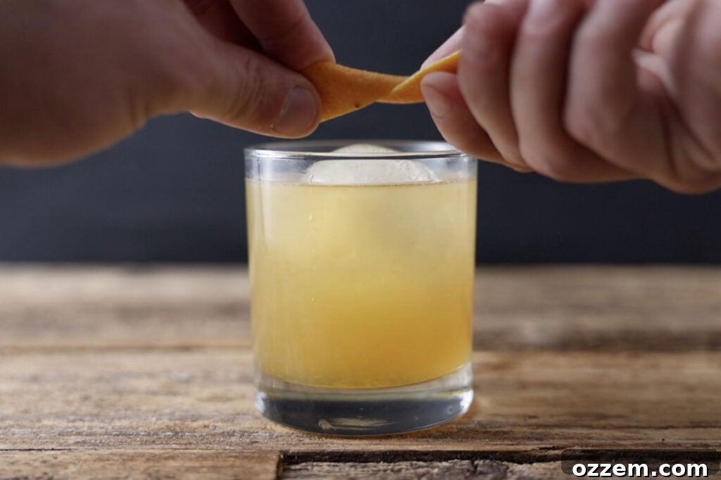 Expressing orange peel over cocktail.
