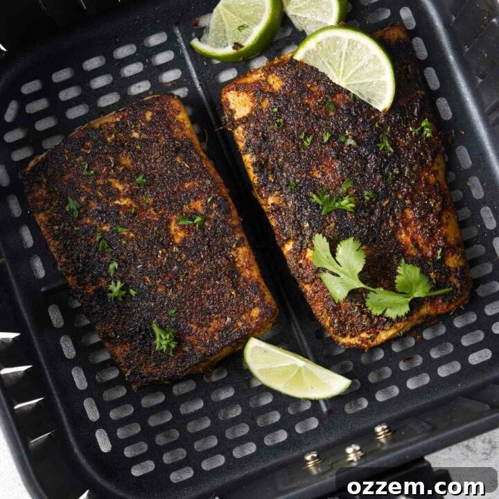 Blackened mahi mahi fillets in an air fryer basket, showing a perfect crisp and seasoning.