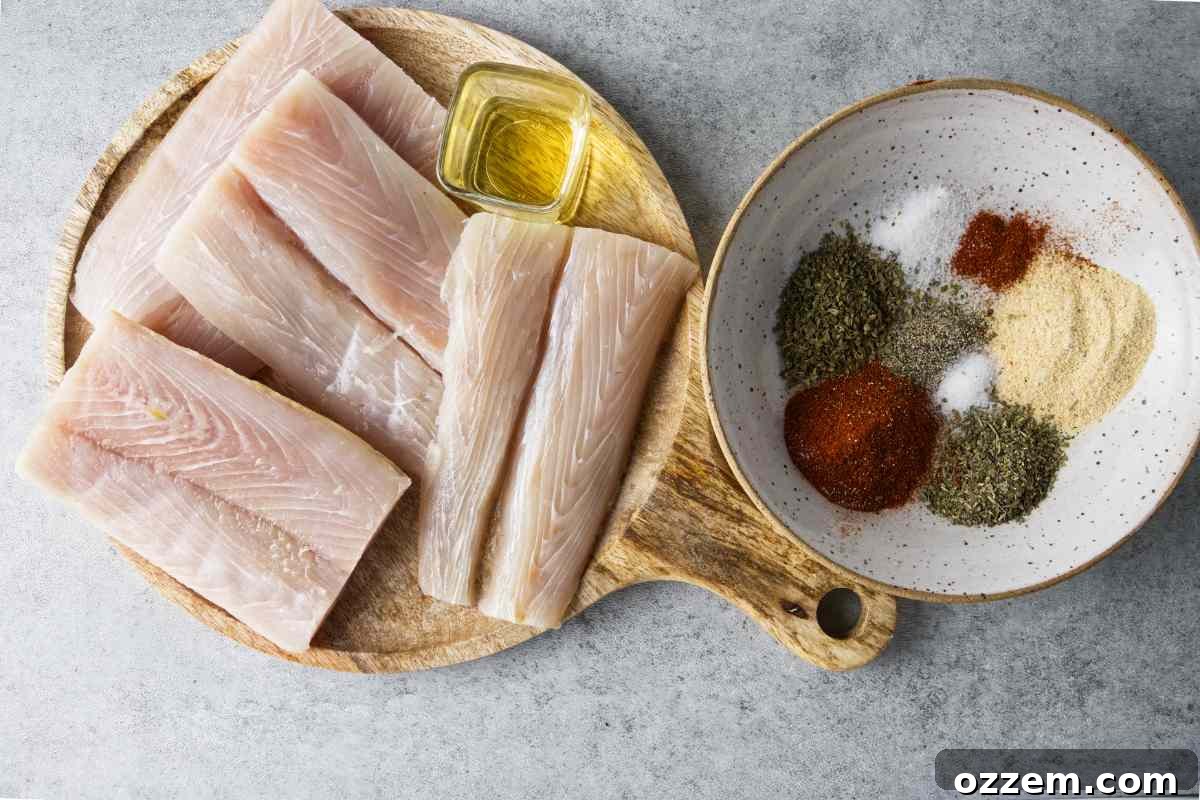 Golden Air Fryer Mahi Mahi 4 Various ingredients laid out for making air fryer mahi mahi, including fresh mahi mahi fillets, a bowl of blackening spices, a bottle of oil, and the components for the dill caper sauce.