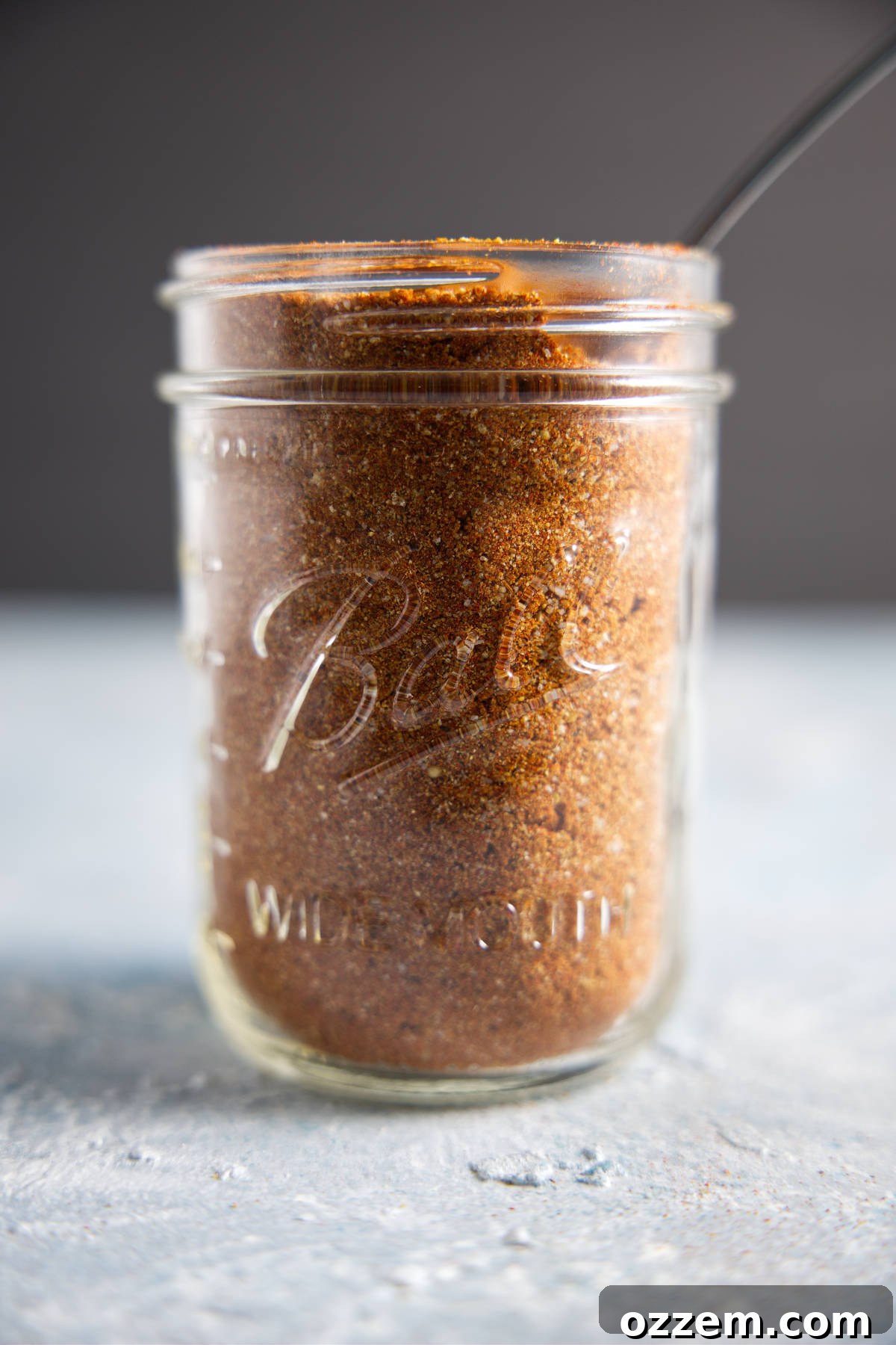 A beautifully illuminated mason jar full of homemade pork dry rub, ready for use.