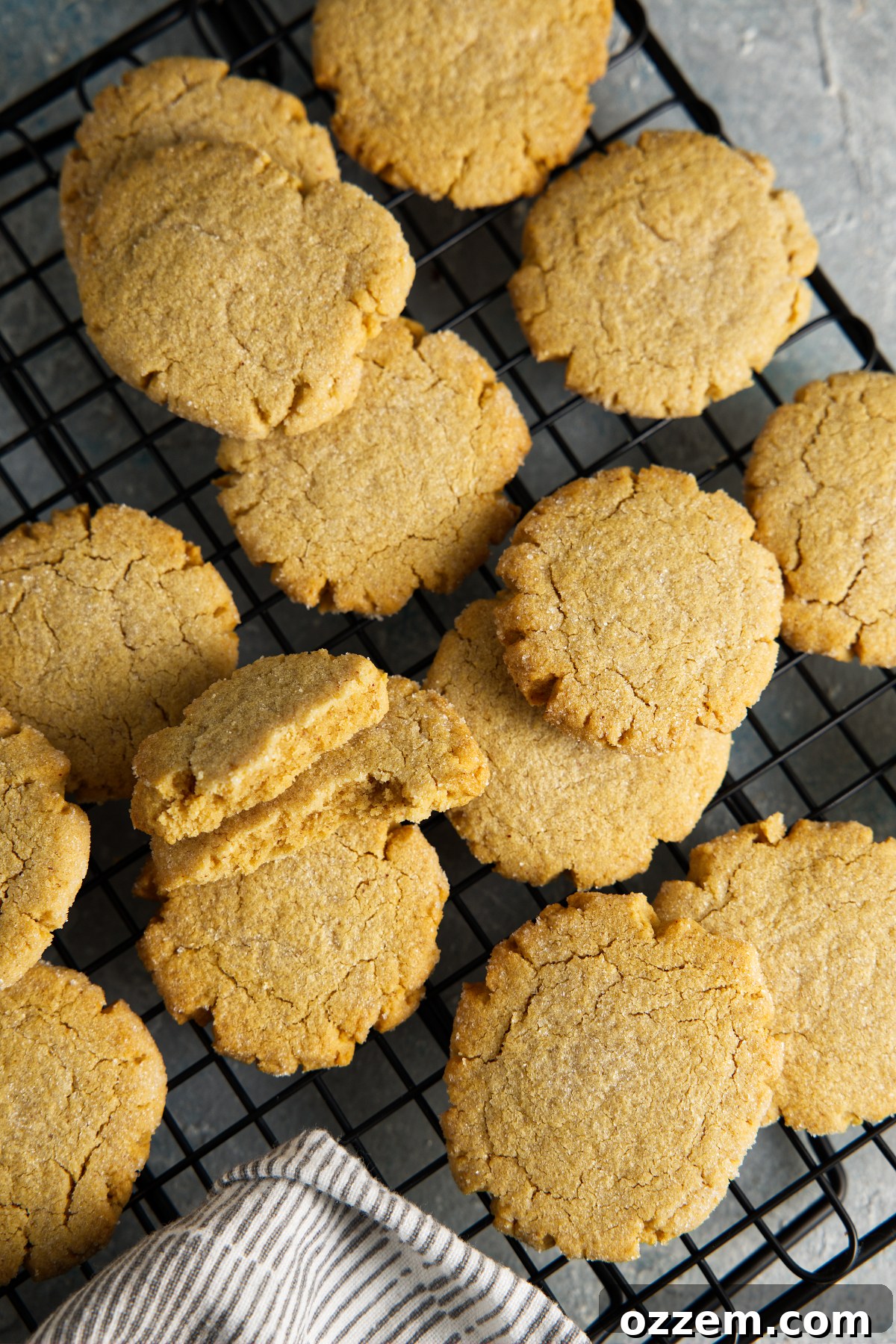 Freshly baked air fryer peanut butter cookies arranged neatly on a wire cooling rack, emitting a warm aroma and signifying readiness for enjoyment.
