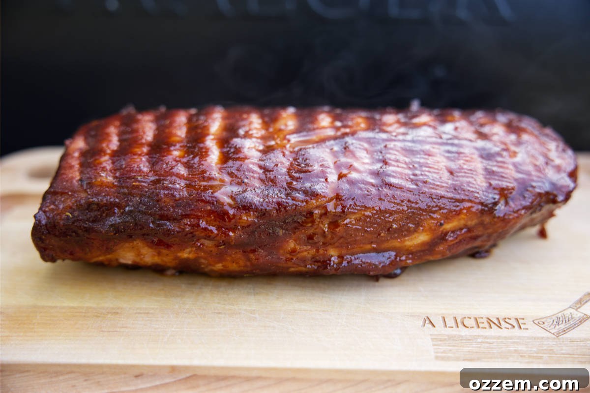 Resting pork loin on cutting board with BBQ sauce caramelized.