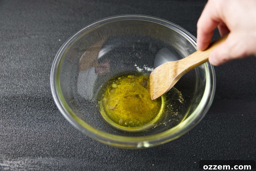 Pork Loin Taco Remix 4 Whisking together fresh lime juice, olive oil, and kosher salt in a clear glass mixing bowl to create the flavorful dressing for the avocado salsa.
