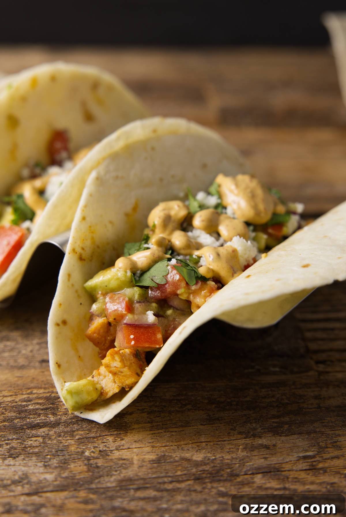 Pork Loin Taco Remix 8 A close-up shot of several richly loaded pork loin tacos, beautifully garnished with a generous drizzle of smoky chipotle lime crema, promising an explosion of flavor and a visually appealing dish.