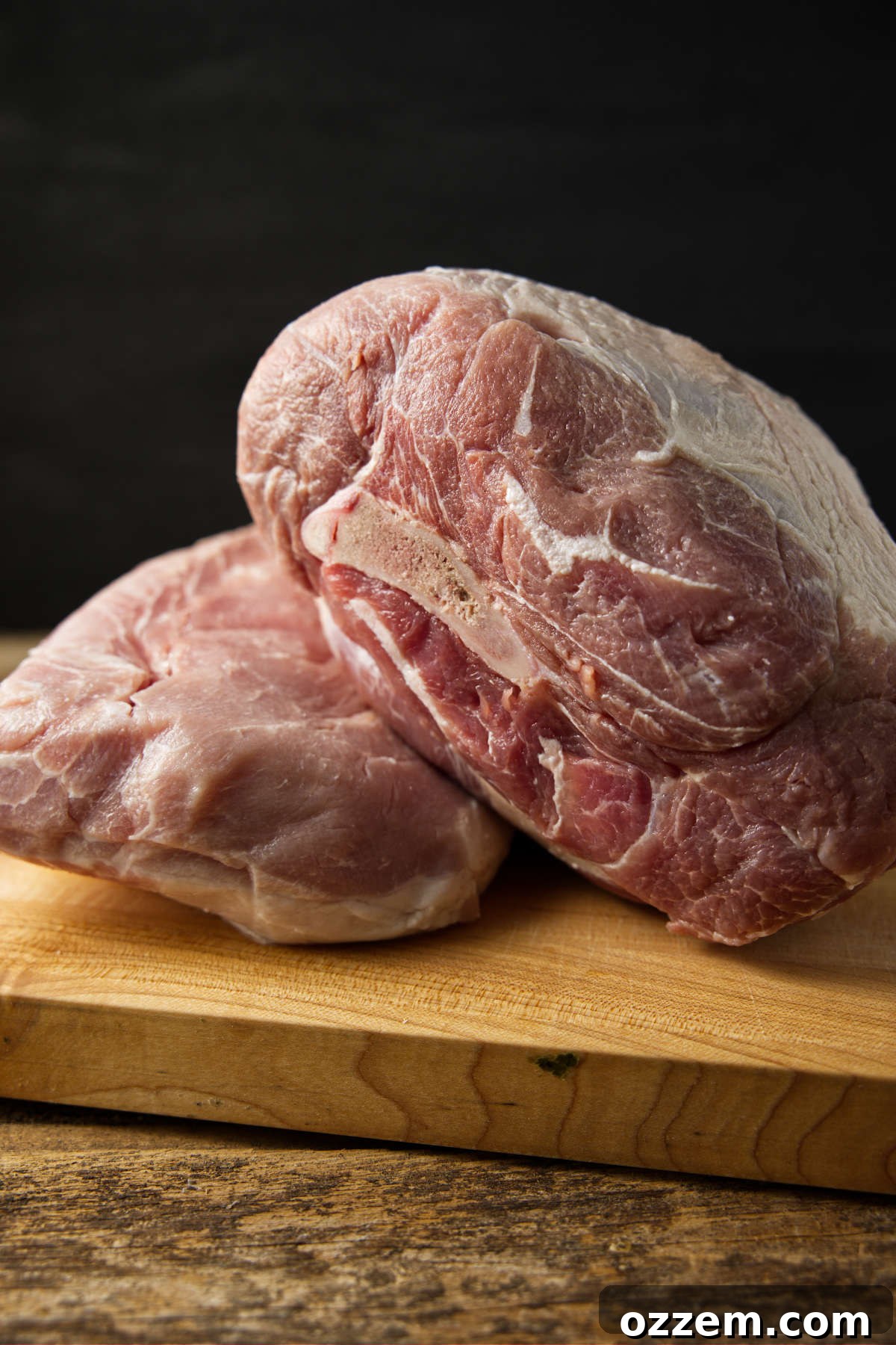 The Pork Loin Shoulder Showdown 7 Pork shoulder and pork loin stacked on top of eachother on butcher block.