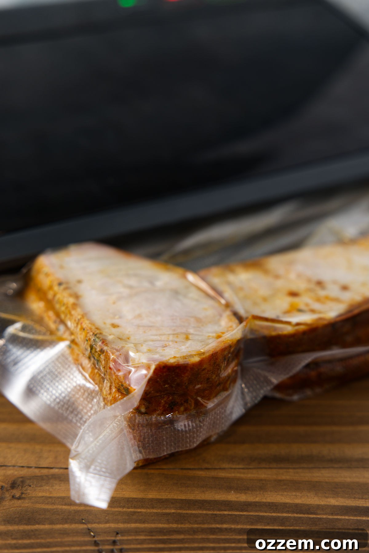 Vacuum sealing sliced pork loin in bag.