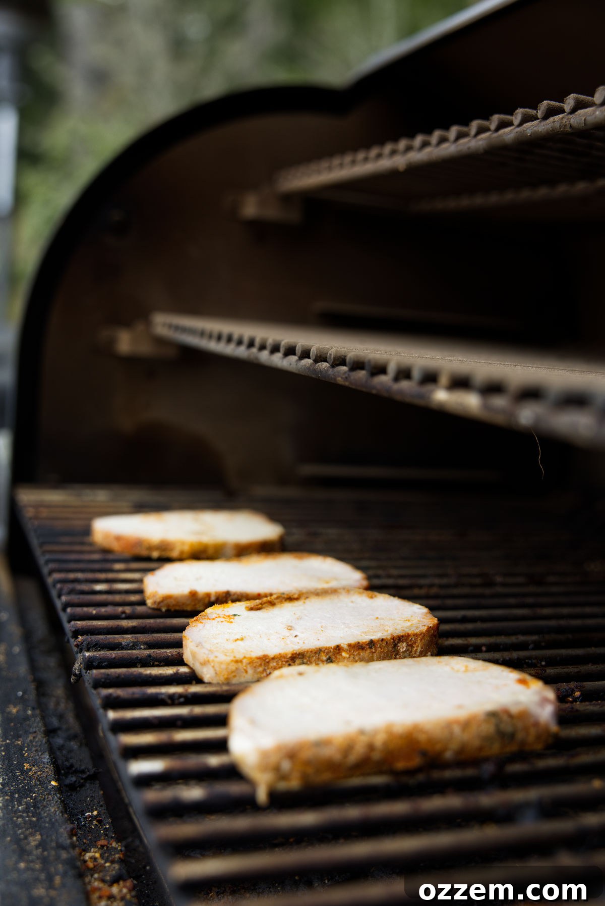 Reheating cooked and sliced pork loin on smoker grill.