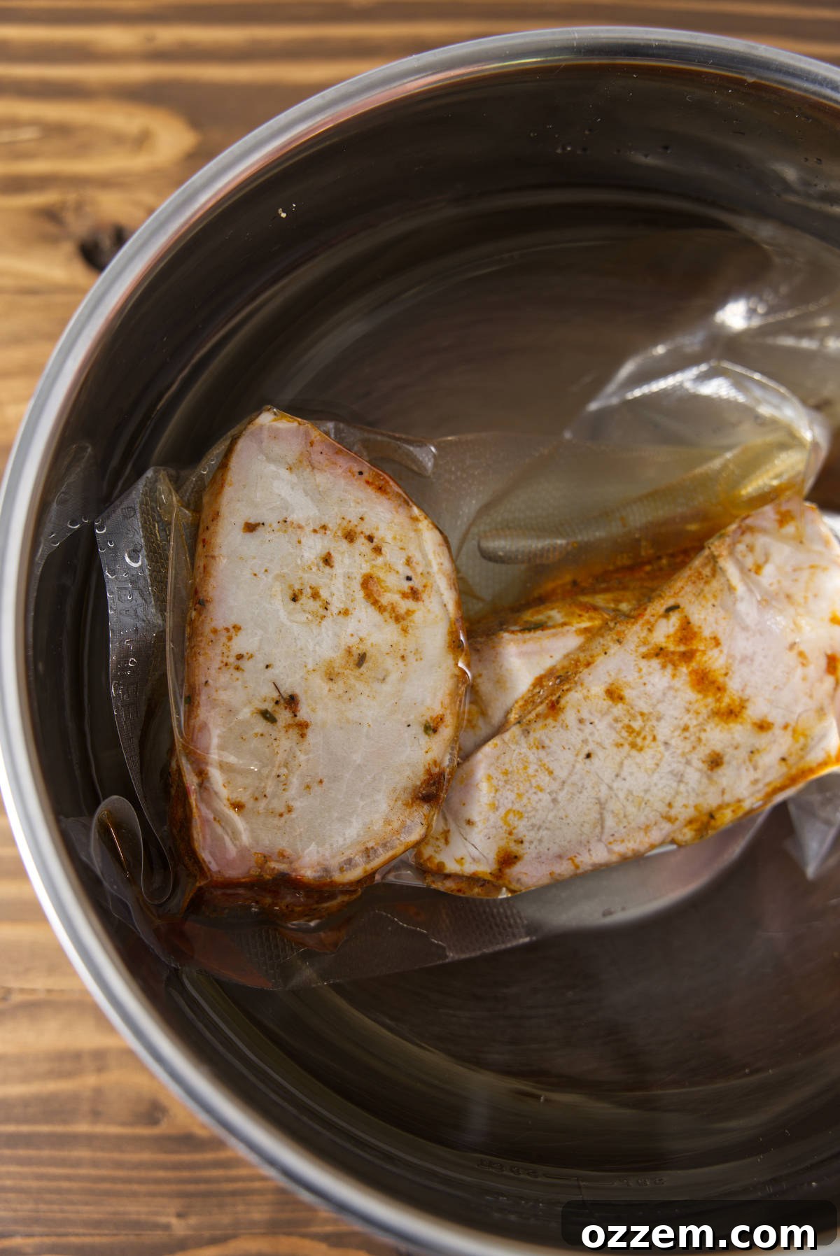 Sliced pork loin in vacuum sealed bag thawing in a water bath.