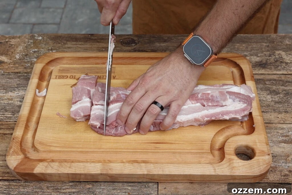 Neatly arranged cubes of pork belly on a cutting board, ready for seasoning and smoking, demonstrating consistent sizing.