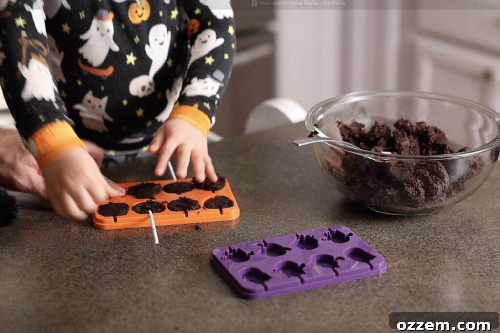 Molding cake pops and adding a stick.