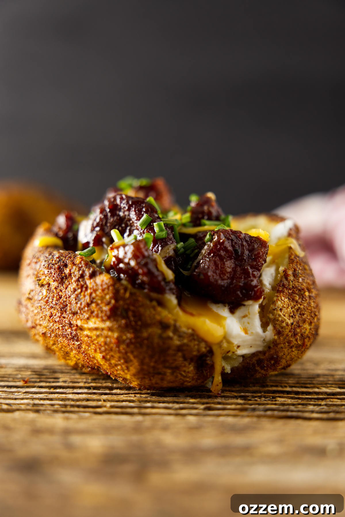 Fully loaded smoked baked potato with melted cheese, chives, sour cream, and brisket