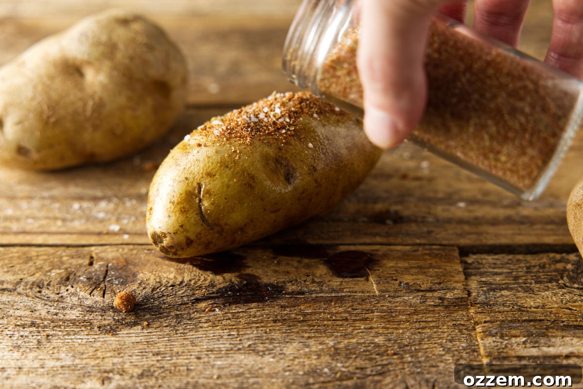 Sprinkling BBQ seasoning on russet potatoes.