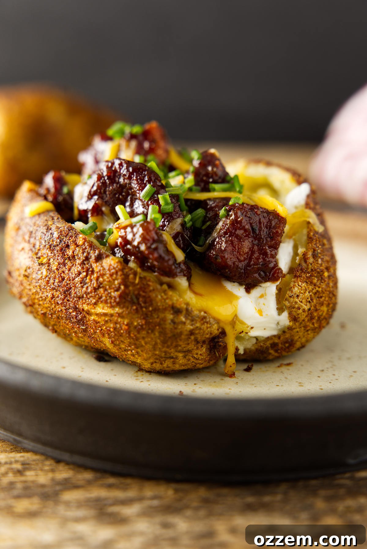 Plated fully loaded smoked baked potatoes with crispy skin.