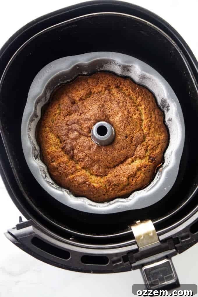 Golden Air Fried Banana Bundt 3 A delicious banana bundt cake nestled in an air fryer basket, ready for baking.