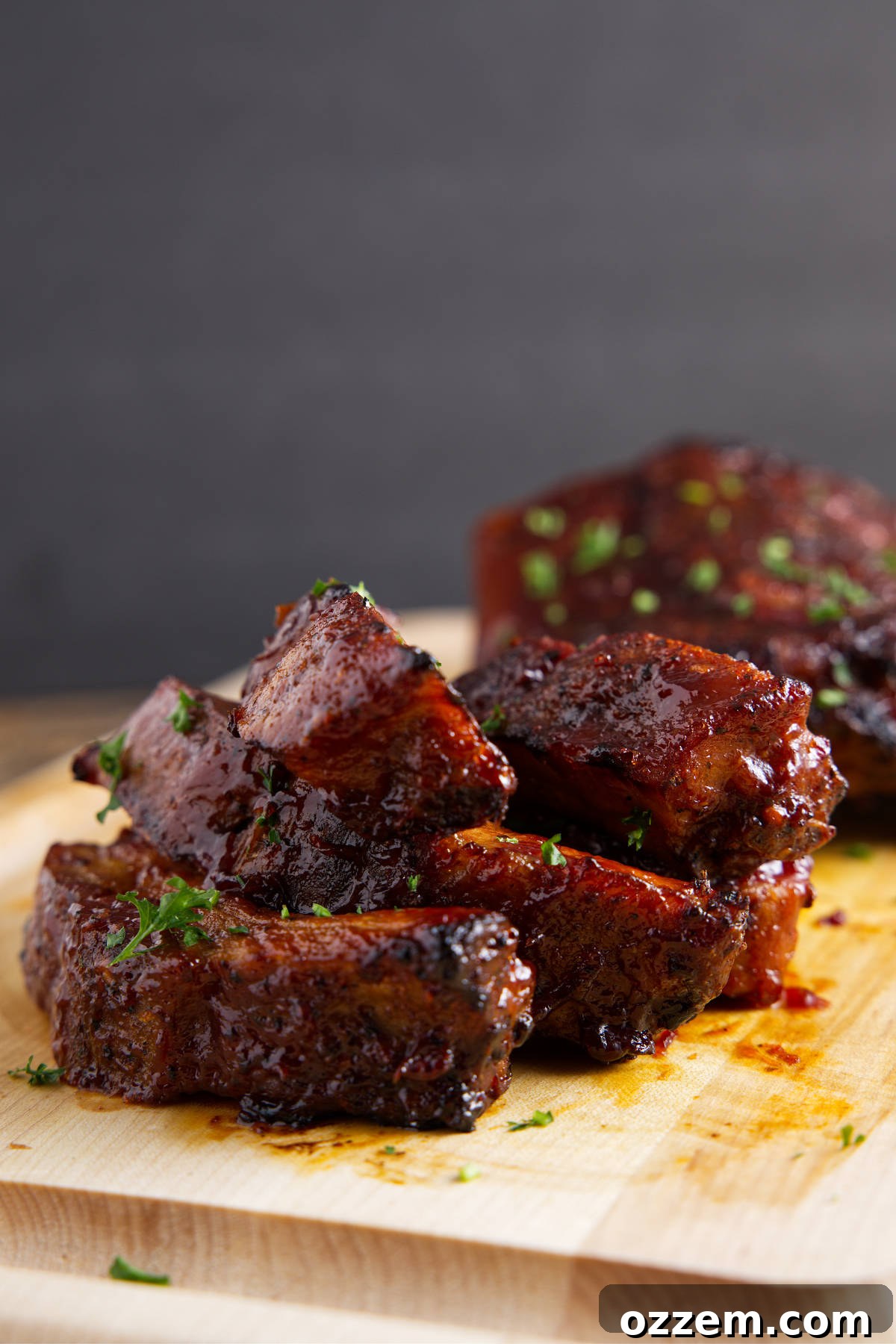 Perfectly reheated, saucy pork ribs resting on a wooden cutting board, ready to be served.
