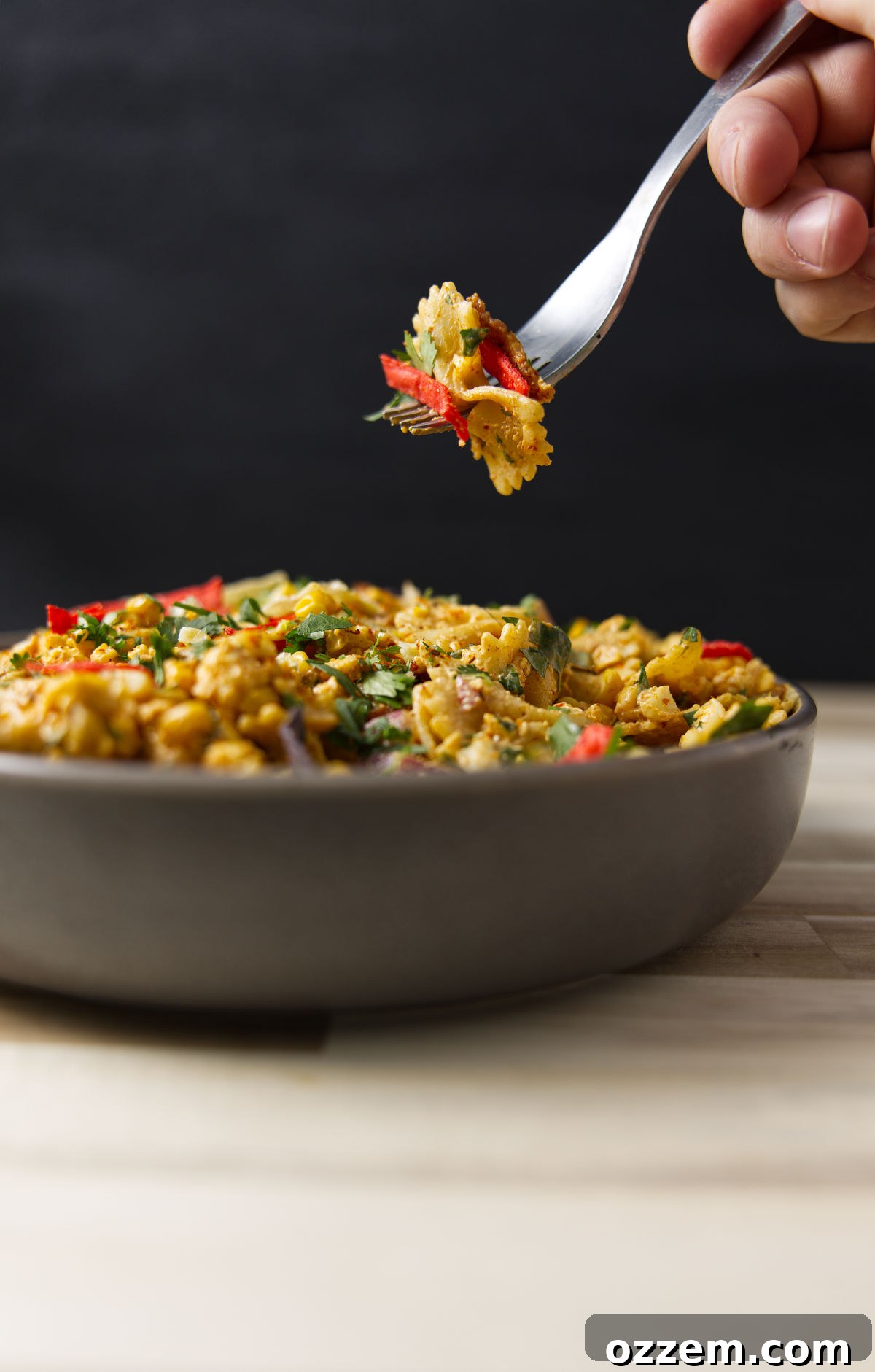 Mexican Street Corn Pasta Salad 2 Fork shot with a bite of Mexican street corn pasta salad above a heaping full bowl.