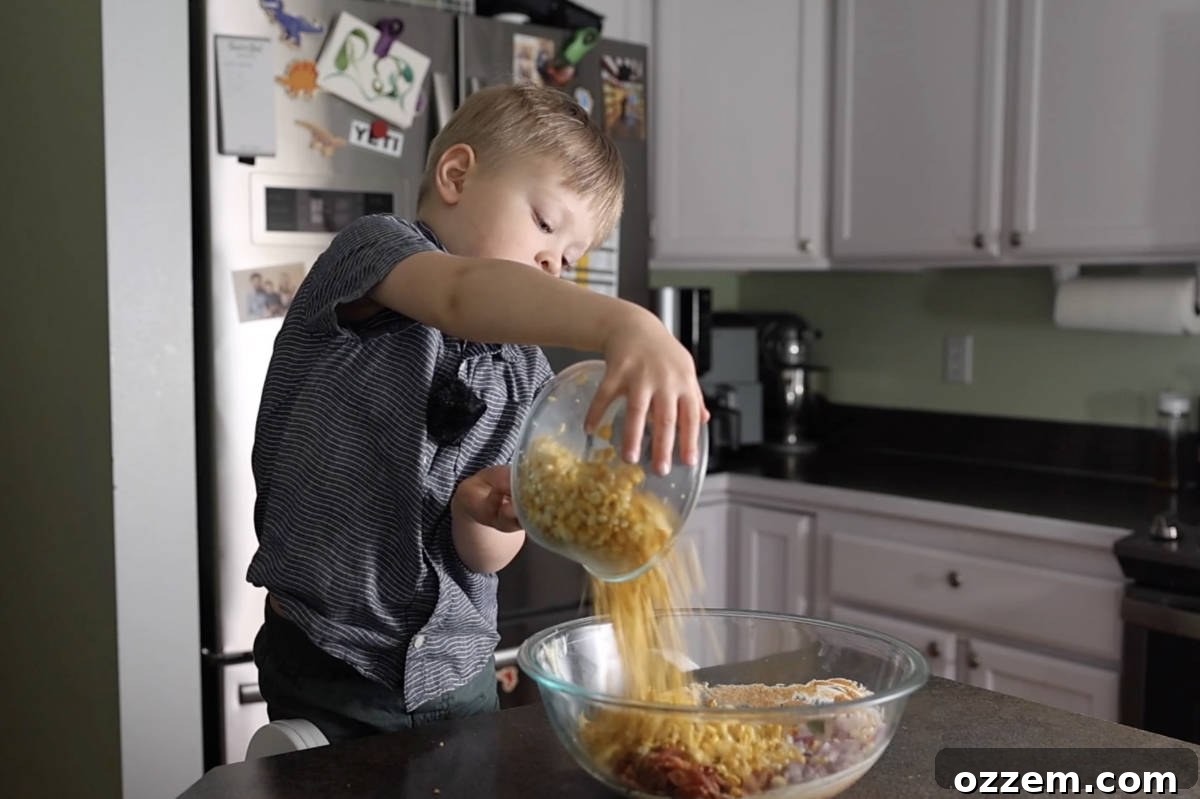 Mexican Street Corn Pasta Salad 8 Adding corn into the bowl of street corn pasta salad.