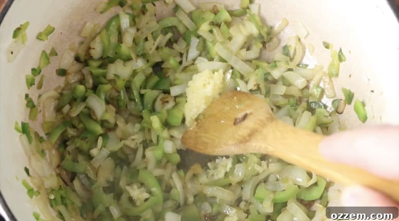 photo of veggies cooking in dutch oven, onion, green bell peppers, jalapeño, and garlic