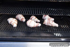 Smoky Traeger Stuffed Chicken Legs 15 Bacon wrapped chicken legs on smoker grates.
