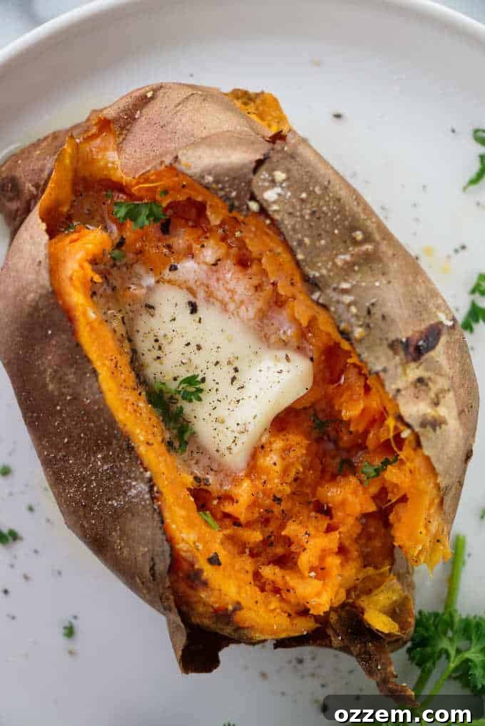 Air Fryer Sweet Potato Perfection 2 Air fryer baked sweet potato served with a pat of butter, a sprinkle of salt, and freshly ground black pepper, ready to be enjoyed.