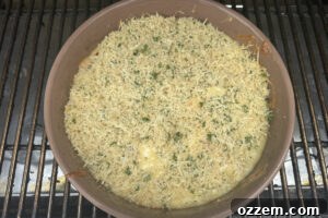 Smoked queso dip in bowl on the smoker grates.