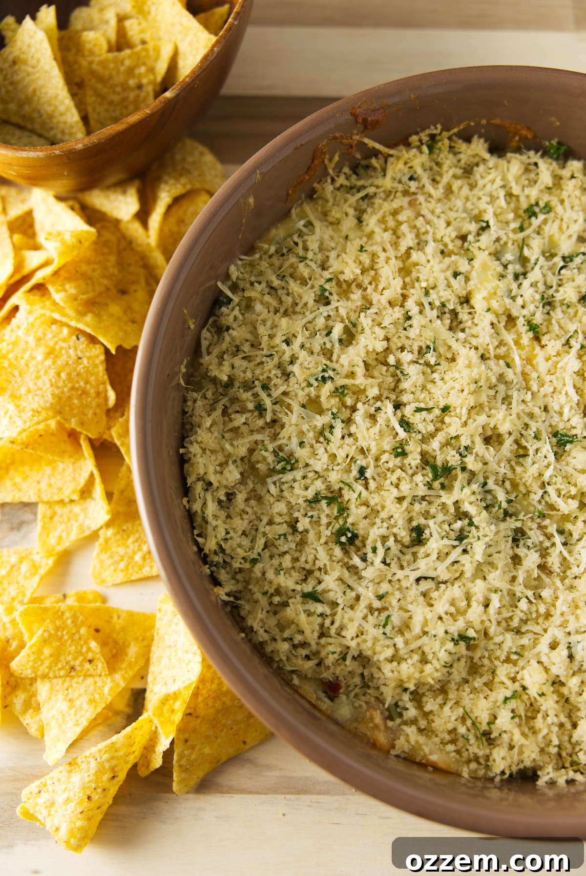 Overhead shot of a large bowl of smoked jalapeño popper dip with a bread crumb topping.