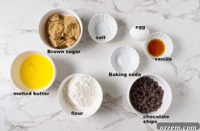 Ingredients laid out for air fryer deep dish chocolate chip cookie bowl: flour, brown sugar, butter, chocolate chips, egg, baking soda, vanilla, salt.