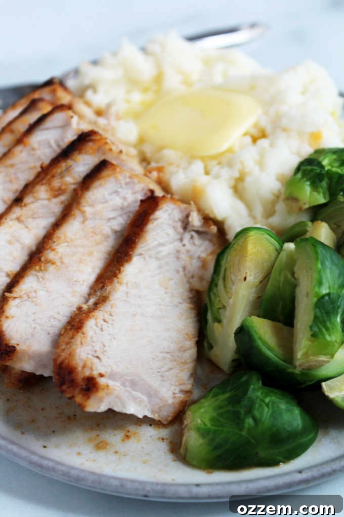 Smoky Chipotle Air-Fried Pork Chops 3 A plated serving of chipotle air fryer pork chops alongside mashed potatoes and green beans.