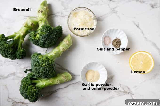 Crispy Lemon Parmesan Air Fryer Broccoli 4 A flat lay of fresh broccoli, a lemon, a block of parmesan cheese, and various spices.