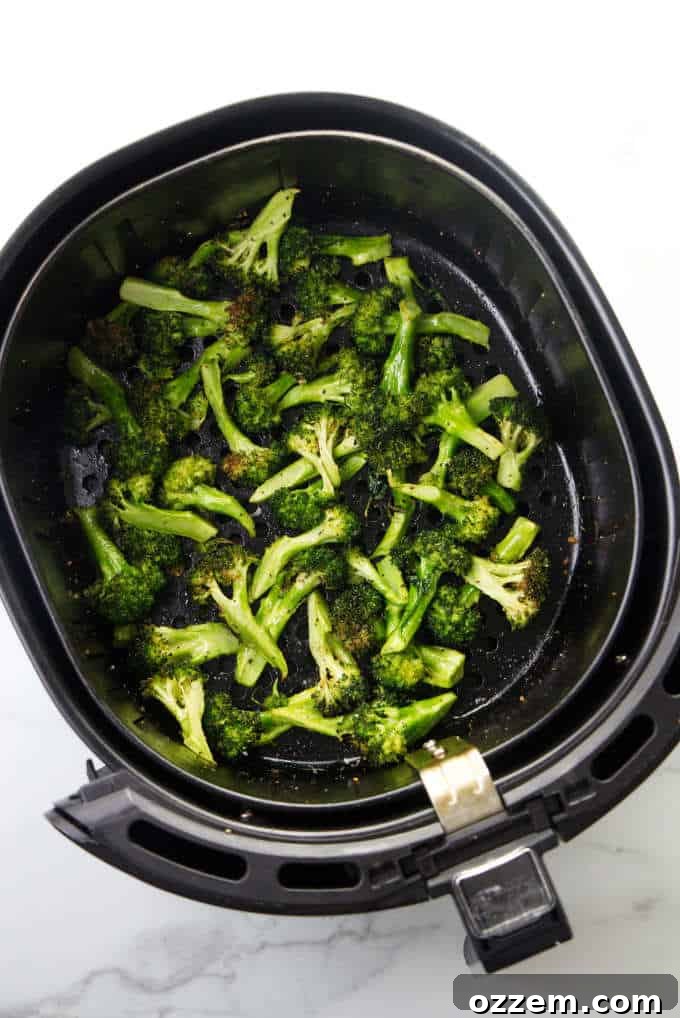 Air fryer broccoli with parmesan and lemon on a serving plate.