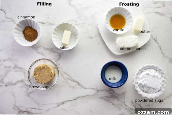 Ingredients for cinnamon roll filling and frosting, including softened cream cheese, butter, brown sugar, cinnamon, powdered sugar, and vanilla extract, artistically arranged.