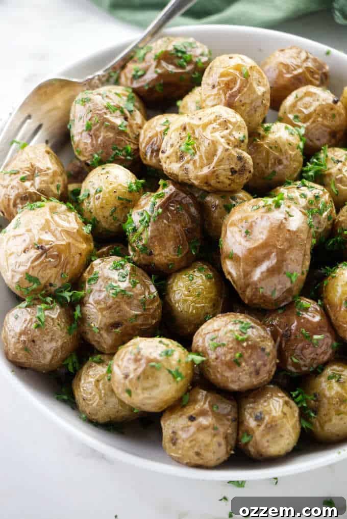 Baby potatoes with melted butter and freshly chopped parsley in a bowl.