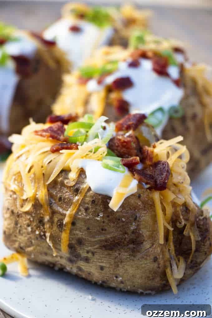 The Ultimate Air Fryer Baked Potato 2 Four air fryer baked potatoes topped with sour cream, cheese, bacon bits, and chopped green onions