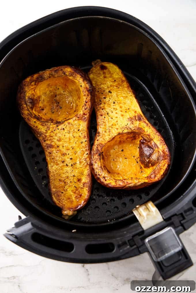 Crispy Air-Fried Butternut Squash with Nutty Sage Butter 4 Two halves of a butternut squash in an air fryer basket.