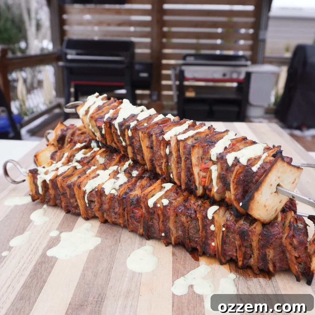 Grilled Tortilla Beef Kebob on a cutting board with a spicy cilantro sauce drizzle.