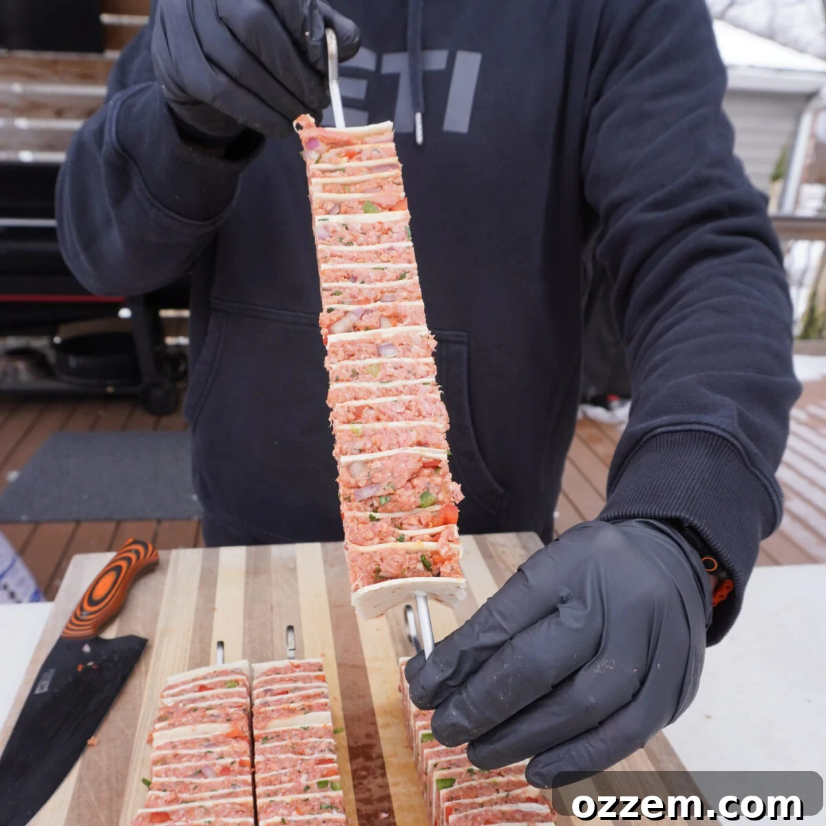 raw tortilla beef kebab on a metal skewer.