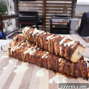 Grilled Tortilla Beef Kebob on a cutting board with a spicy cilantro sauce drizzle.