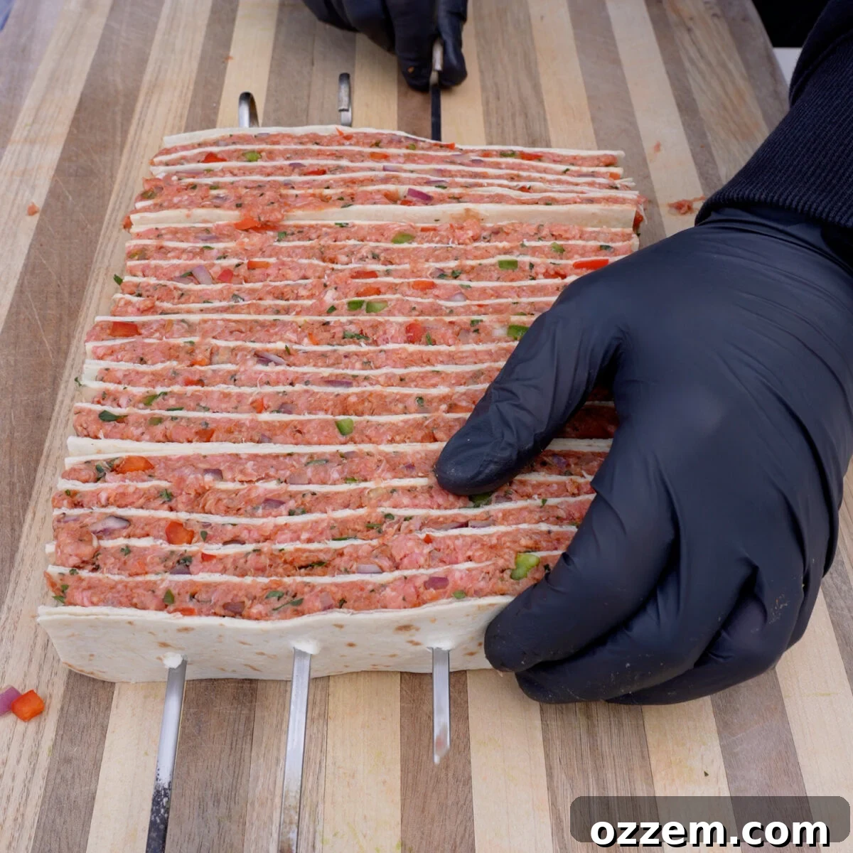 Raw tortilla beef kebabs on skewers.